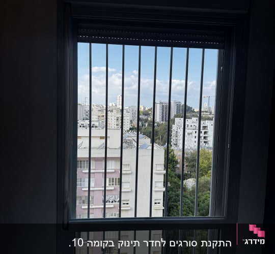 חלון עם סורגים ונוף עירוני ברקע